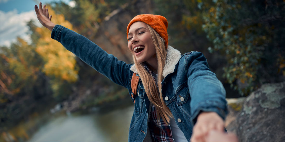 Una ragazza sorridente in un paesaggio montano con lago