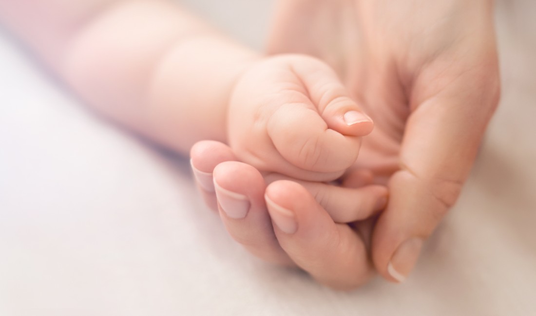 Endometriosi e gravidanza: nell'immagine una mano femminile stringe quella di un neonato