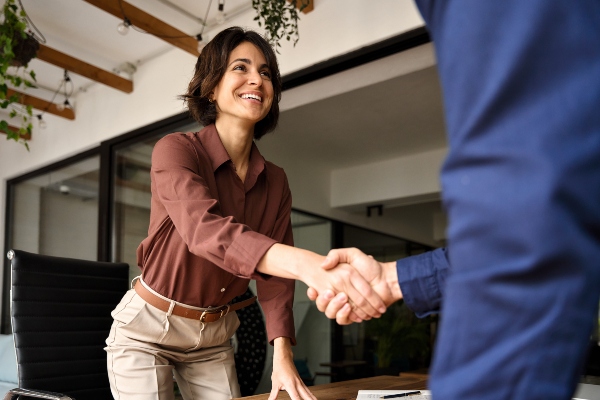 Concept per donne imprenditrici: primo piano di donna che stringe la mano a un collaboratore