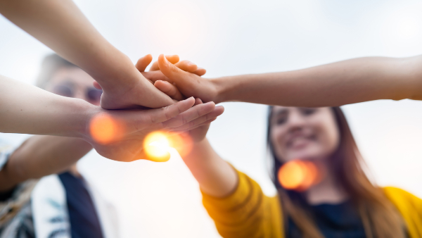 Concept per associazioni di volontariato: volontari mettono le mani le une sulle altre